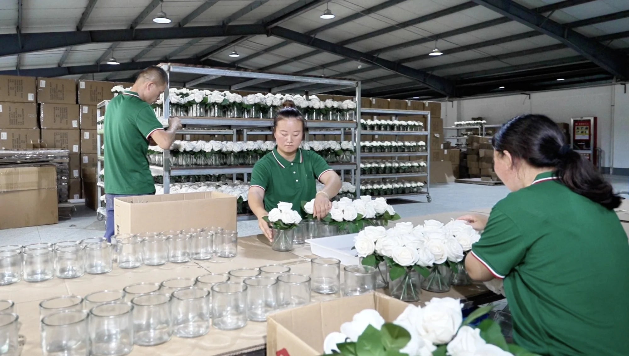 Industry worktable reference showing artificial flower batches and people preparing products
